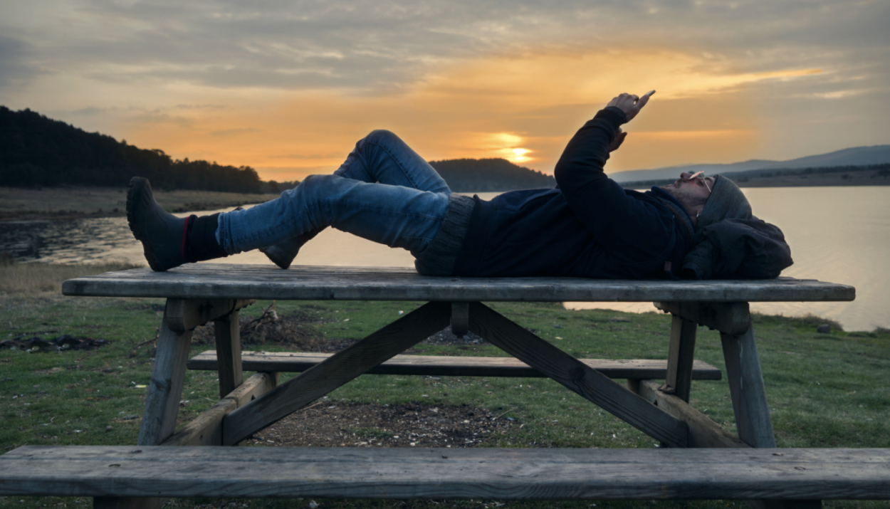 Traveler using phone at campground.