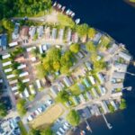 Caravan site island park at lake water edge aerial view closed during winter season