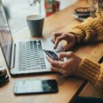 Woman in cafe shopping online with laptop