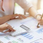 Close-up Businesswomen working together, calculates and estimates business investment turnover on financial data report chart and graph