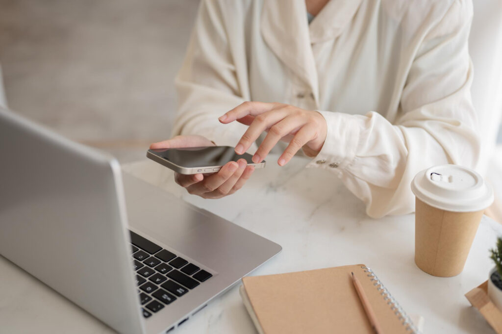 Woman in a white shirt with  a laptop andmanaging her payment options through a campground software 