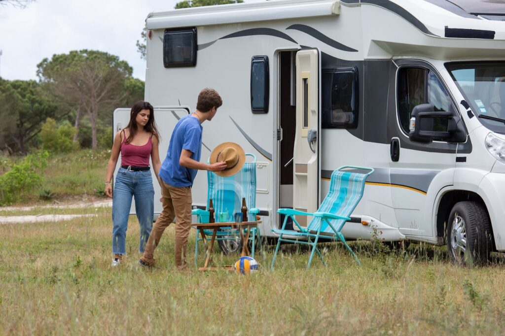 Couple outside of a white camper in the mountains 