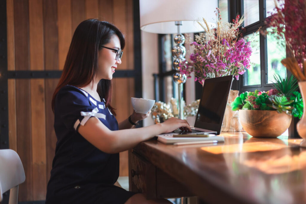 A woman using a laptop managing the reservations of her campsite using campground software