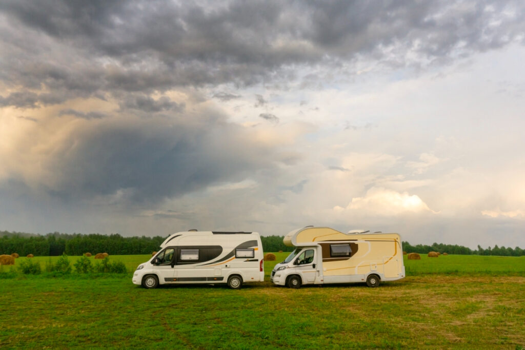 Two camper vans driving in the forest  of a RV park