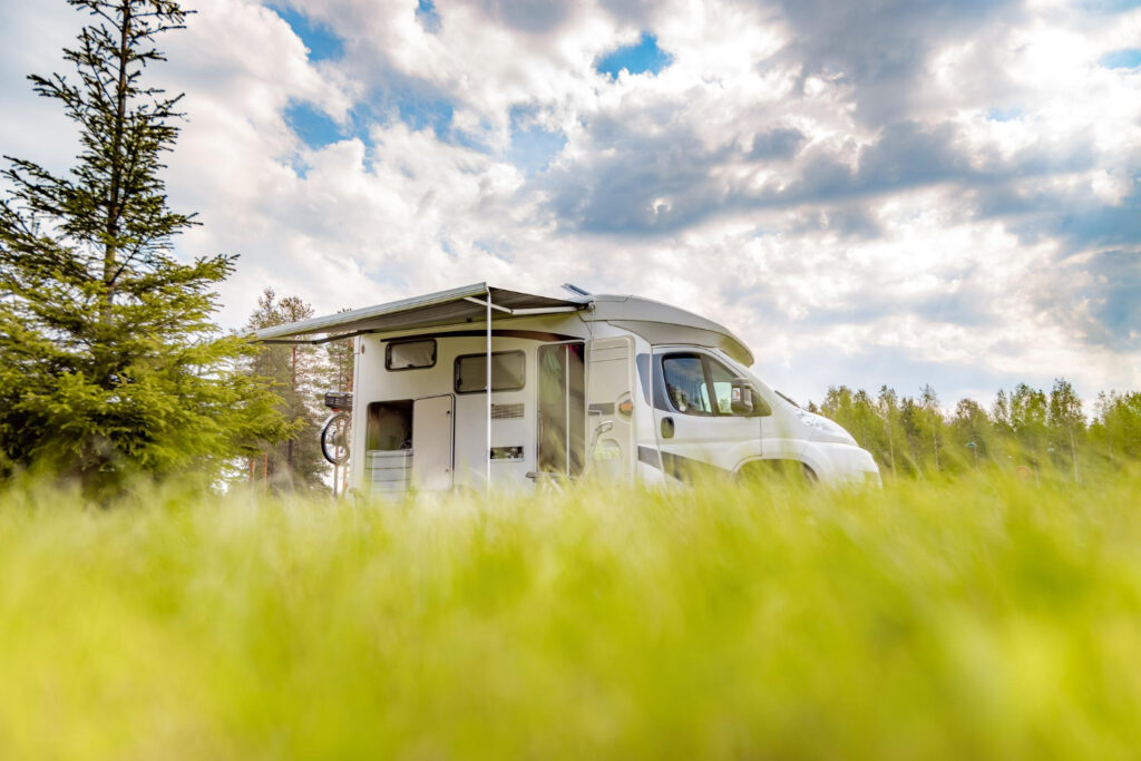 A low POV of a white camper van in the mountains 