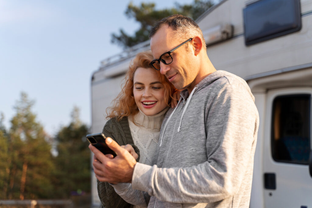 Two people using their phone to check their next campground spot using campsite reservation software