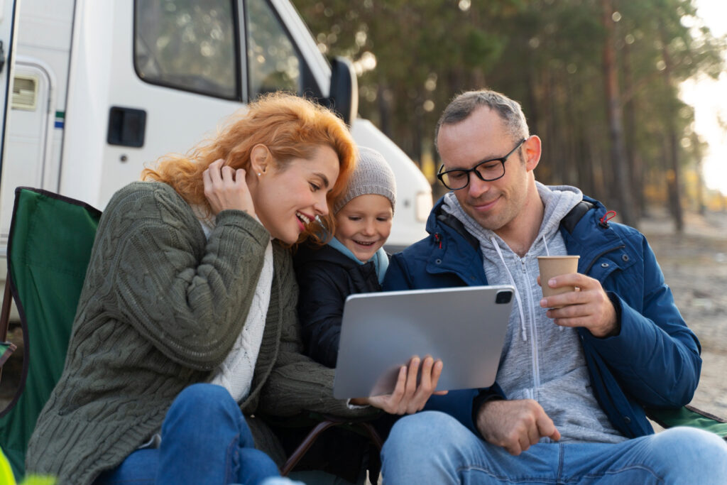 two adults and one kid using a tablet checking the online booking of RV camprgound reservtaion software