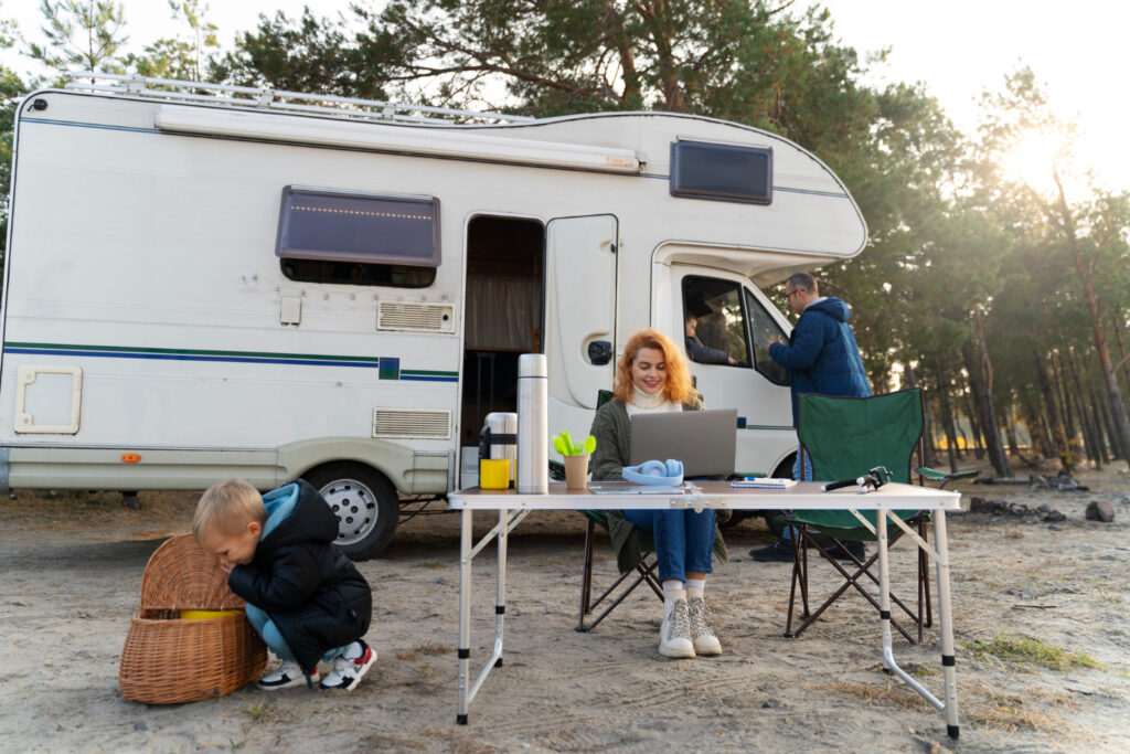 A family of three outside of a camper van enjoying their stay in a RV park