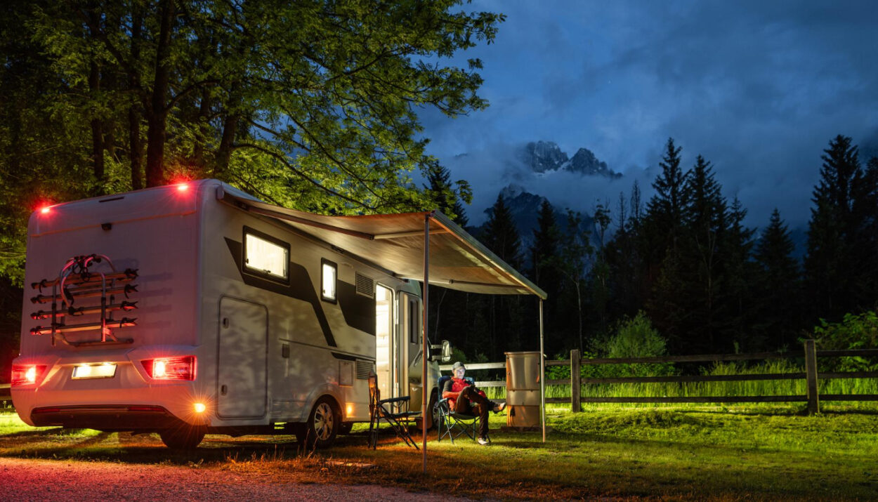 A white camper van with people enjoying a night in nature