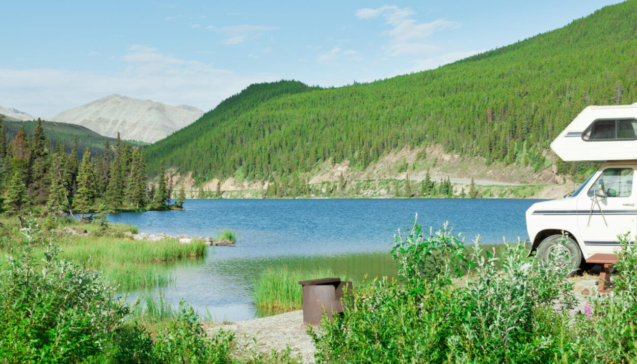 A beautiful view of a camper van in front of a lake