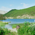 A beautiful view of a camper van in front of a lake