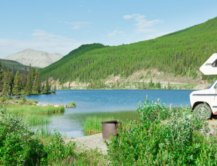 A beautiful view of a camper van in front of a lake