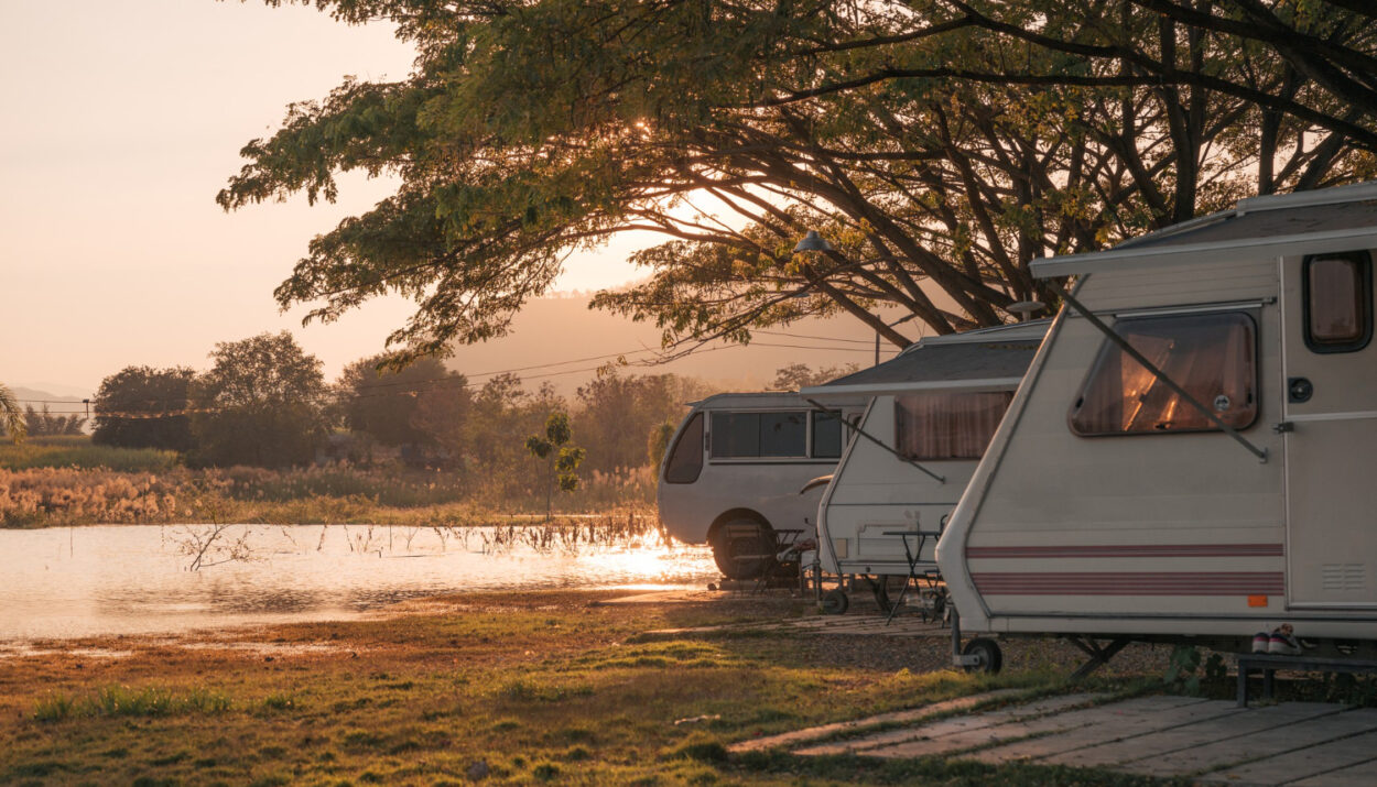 A group of campers in a campground in front of a lake at sunset