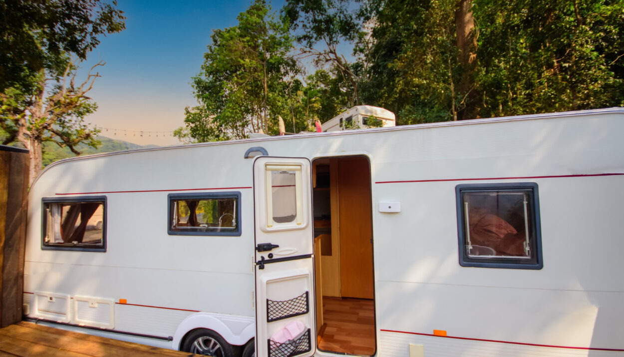 White camper in the forest on a campground spot