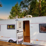 White camper in the forest on a campground spot