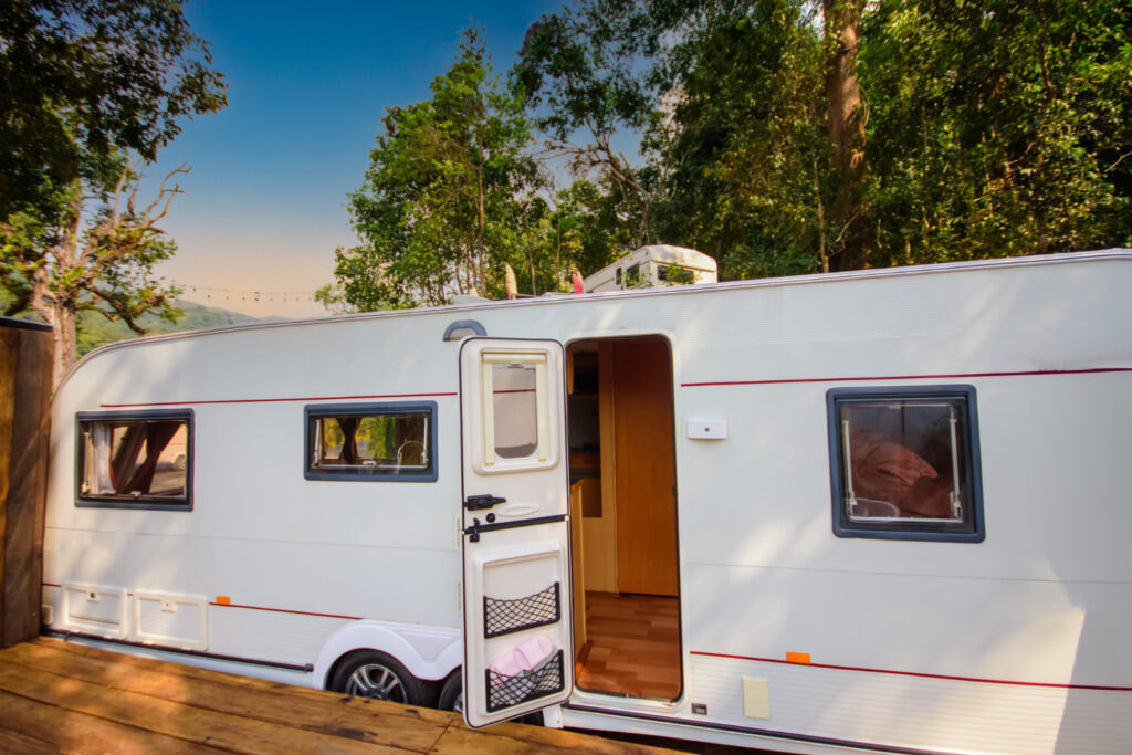 A white camper in nature with the door open 