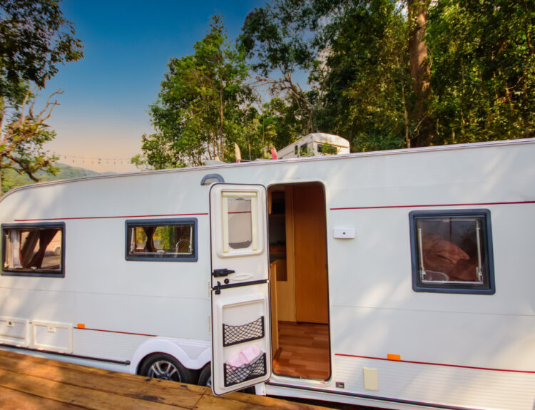 White camper in the forest on a campground spot