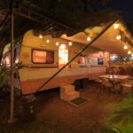 Beige and white campground with lights in front at night