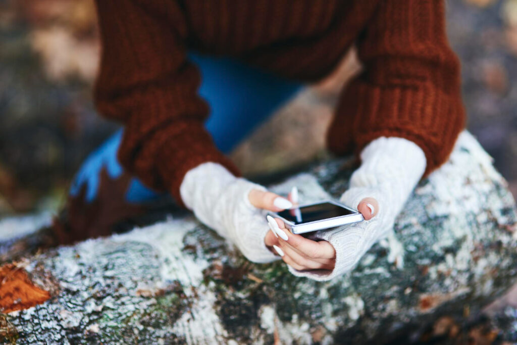 woman using her phone checking her campground software notifications 