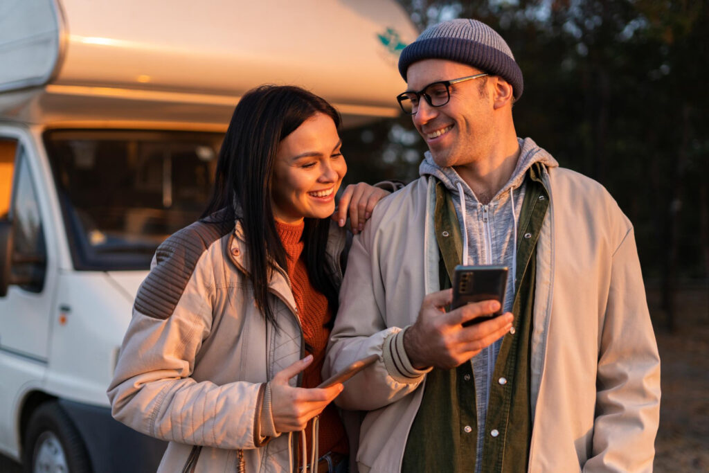 two people checking their phones to see the availability of a RV park using campsite reservation software 