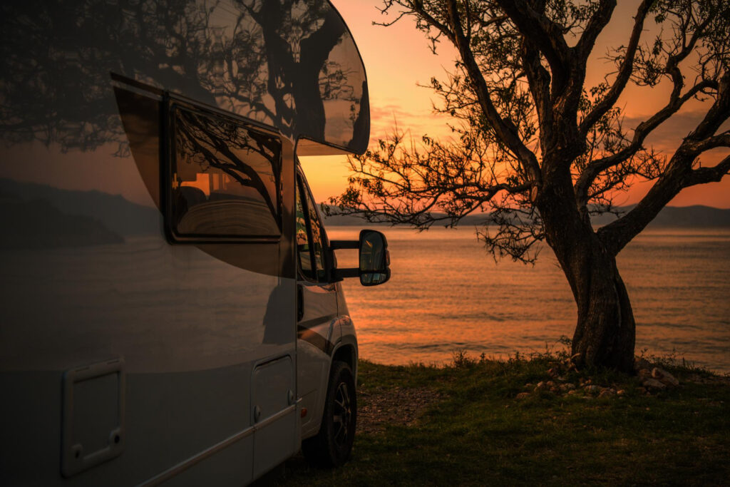 A camper van staying in a RV park with the sunset 