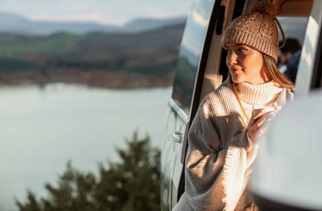 A woman enjoying the view outside of her camper van 