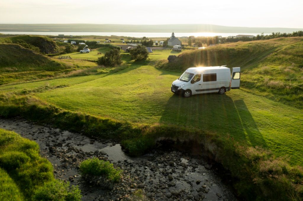 a white camper van in nature with the sun going down 