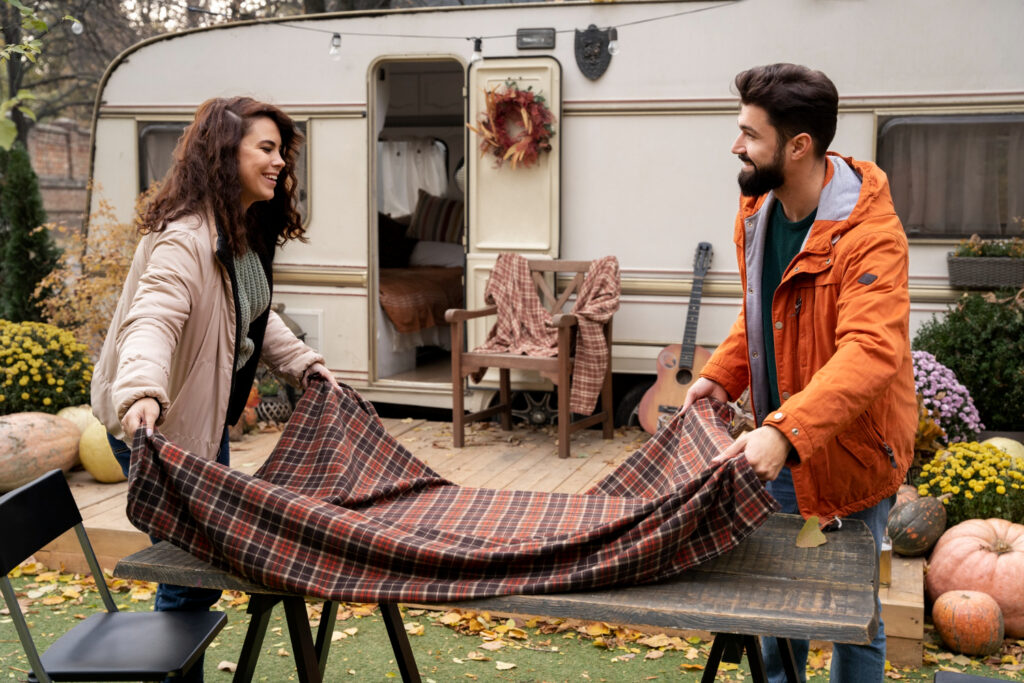 two people preparing the table outside of their camper van 