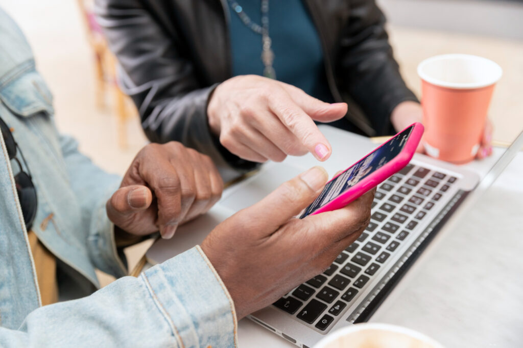 A person holding a pink phone to make a payment through a campground reservation software 