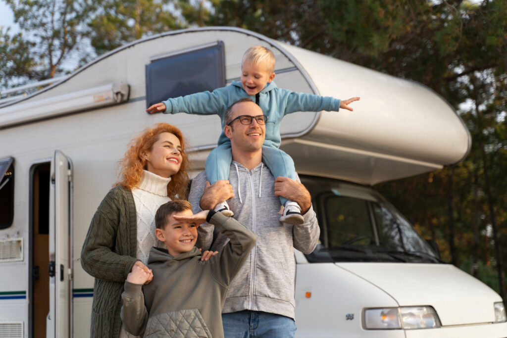 a family enjoying a reunion outside of their camper van in a RV park