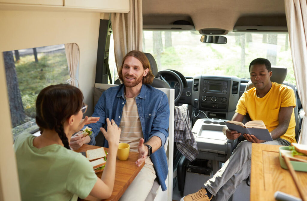 a group of people inside of a camper van talking about their next RV park spot using to campsite management software