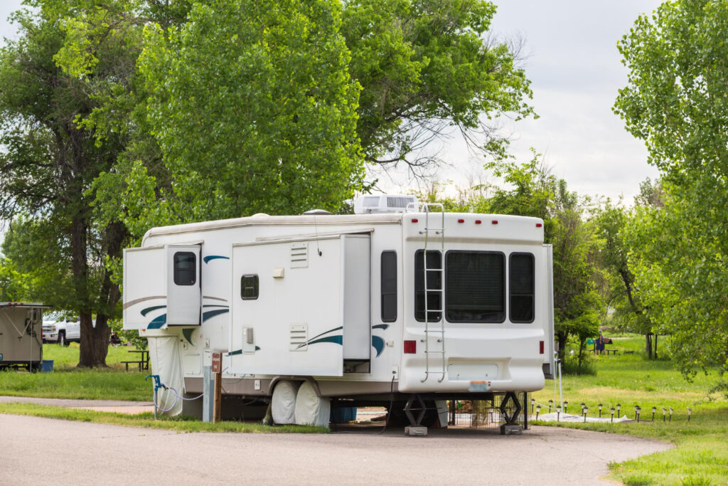 a white with blue details camper van in his campground spot 