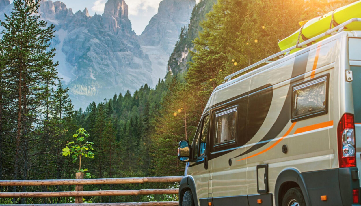 A grey camper van staying in front of a mountain