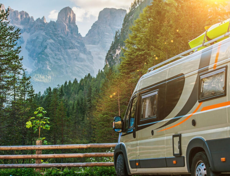 A grey camper van staying in front of a mountain