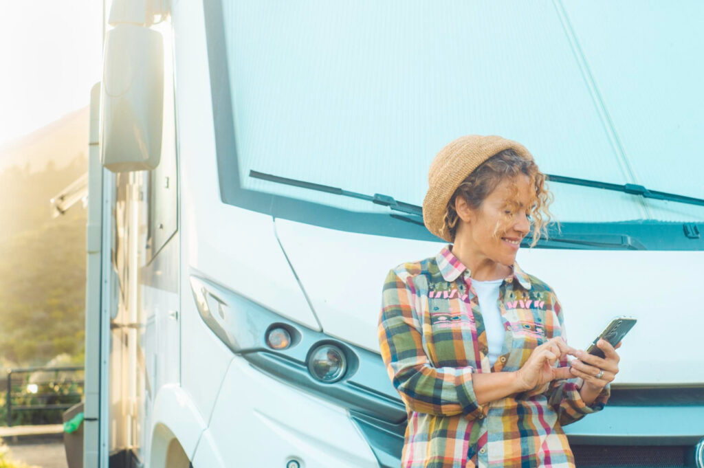 A woman using her phone to see the availability of her next Rv park spot with campground management software 