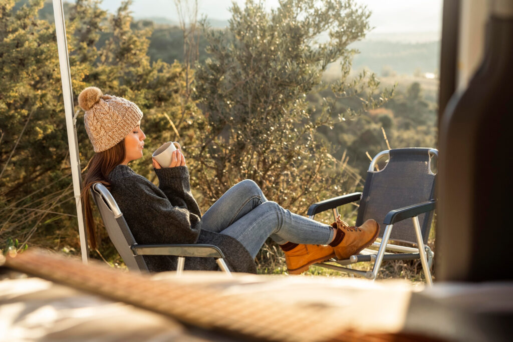 a woman relaxing outside of her campground spot 