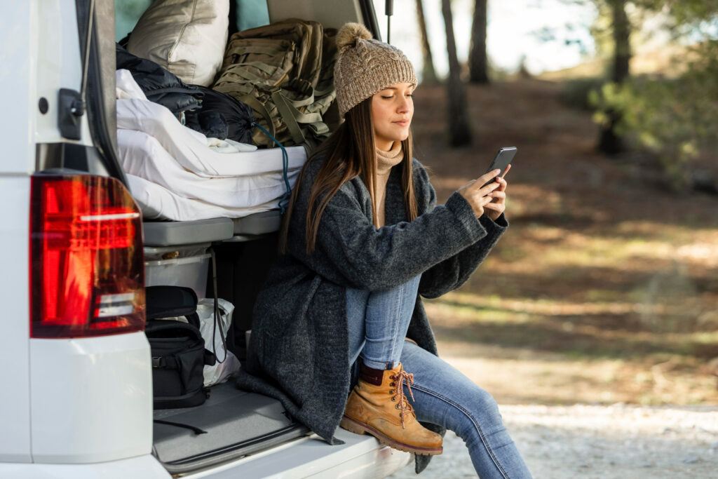 Woman using her phone to check her camping reservation software 