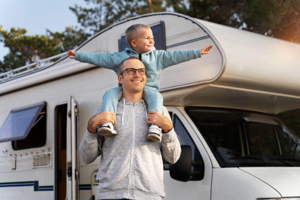 a father and his son enjoying a day in a RV park outside of his camper van