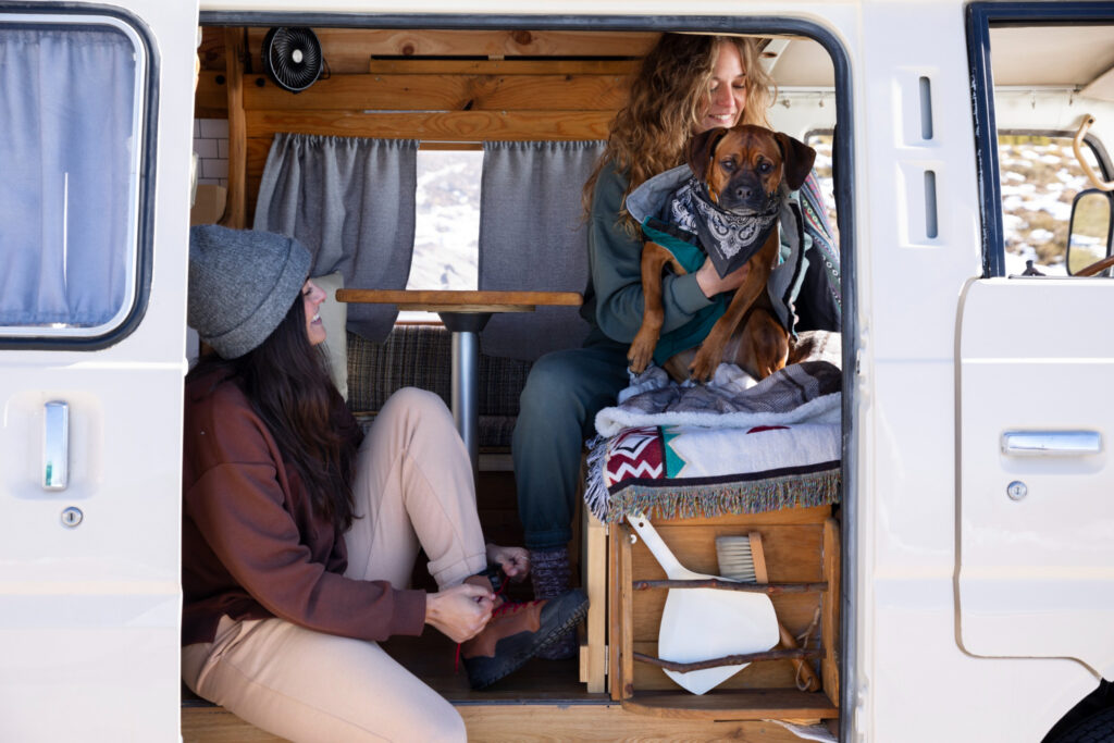 two woman and a dog enjoying their stay in a RV park 