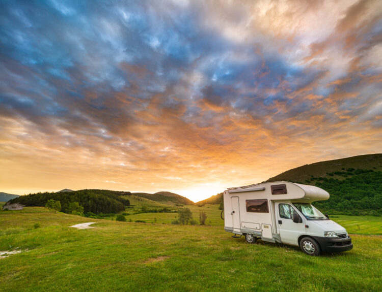 A beautiful view of a camper van in the sunset