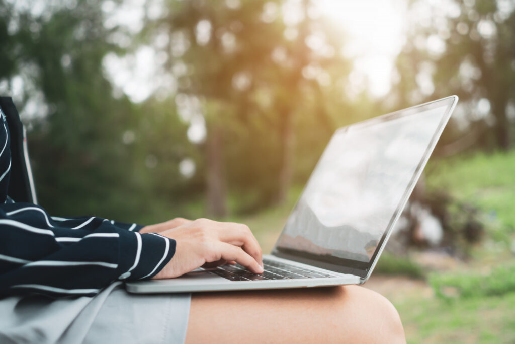 a woman using her laptop to see the list her campground in a marketplace 