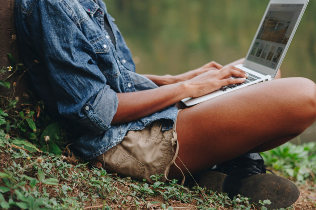 a woman typing in her laptop to check in a RV park using reservation software 