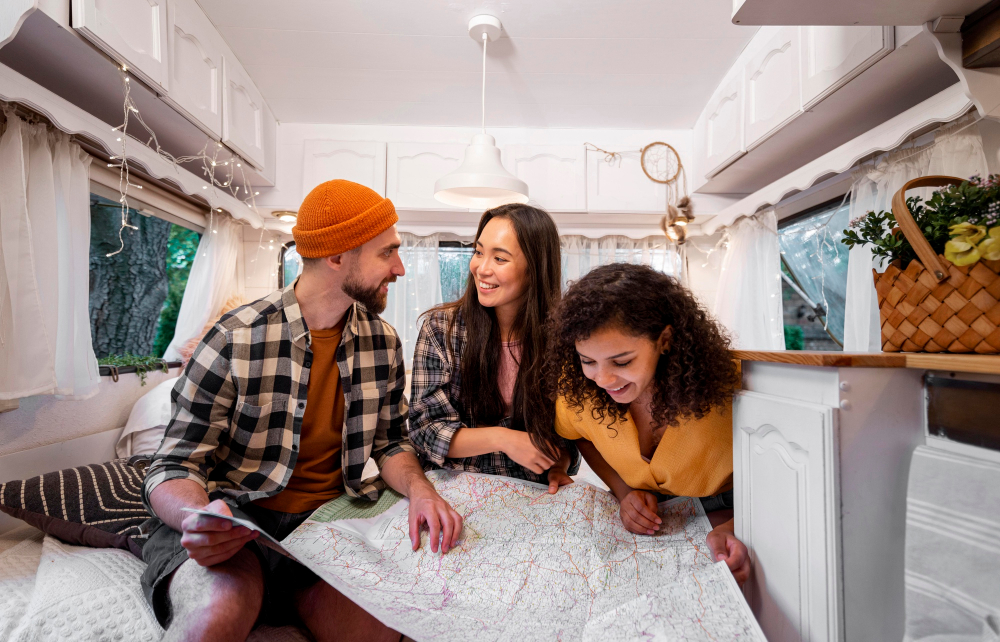 A group of travelers watching a map to look for their next place to visit in side of a camper van 