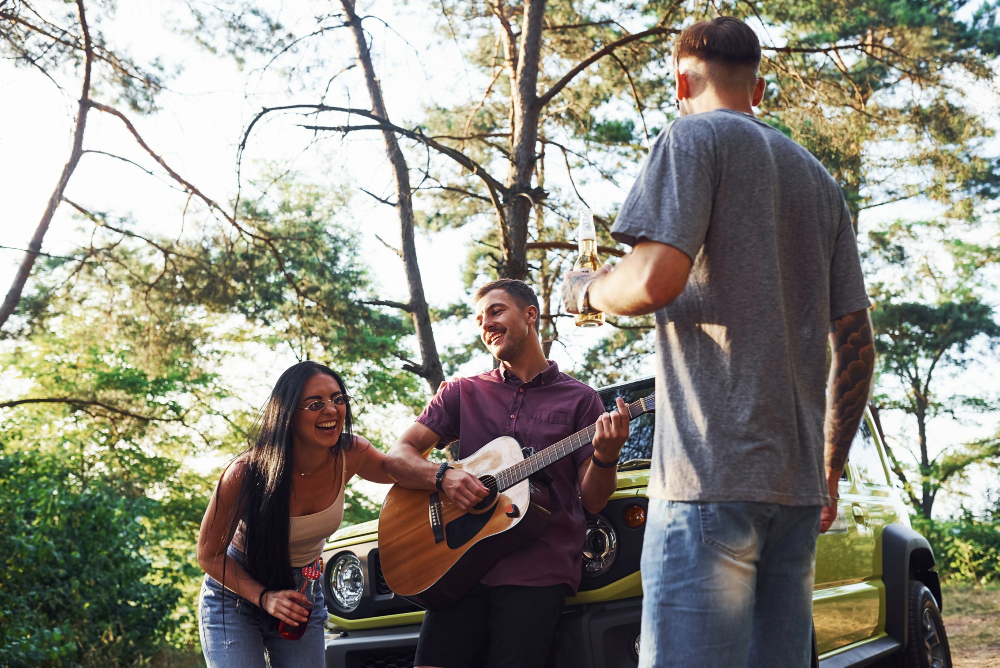 three friends enjoying the music of a guitar in the forest 