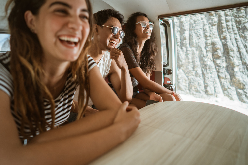 three friends inside of a camper van selecting laughing 