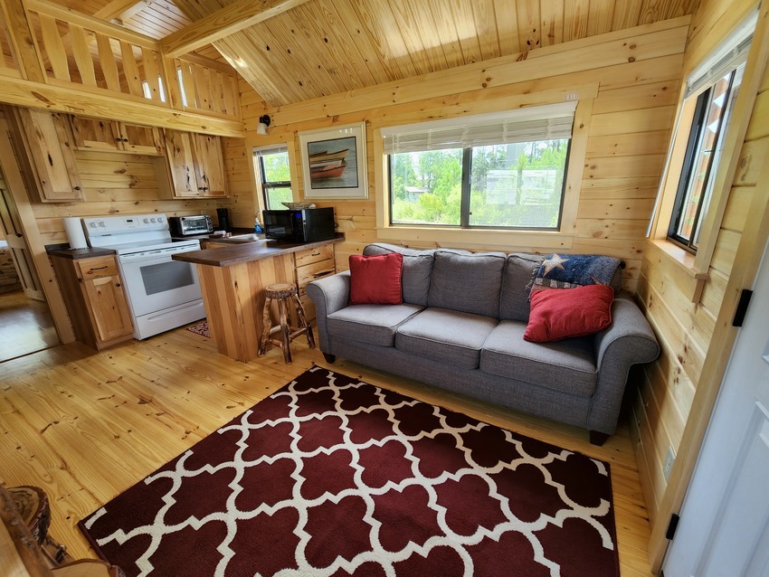 Cabin 1 has a queen bed, bunk beds, bathroom, loft, living room, dining area and full kitchen.